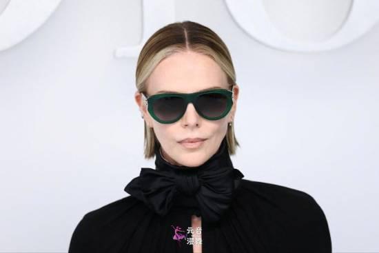 50岁查理兹塞隆出席时装周 短裙黑丝吊带袜大秀长腿